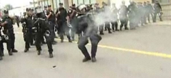 riot police shooting tear gas canister